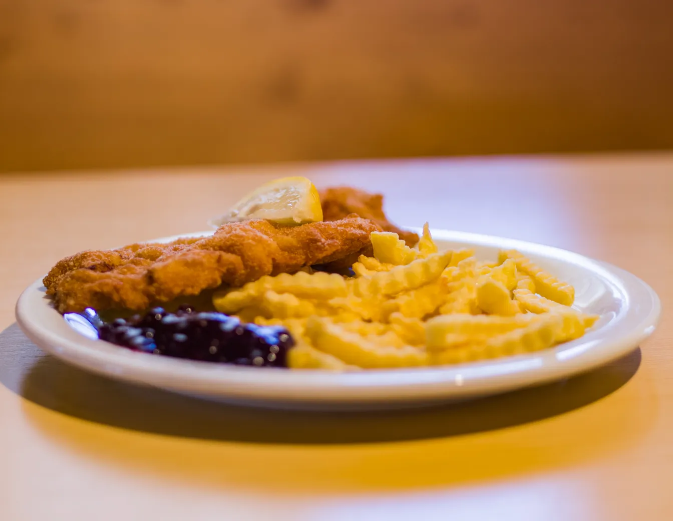 A Wiener Schnitzel with french fries and cranberry jam